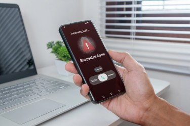 Hand holding cellphone with message saying "Incoming call. Suspected scam."