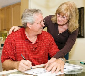 Couple at desk looking happy with budget open