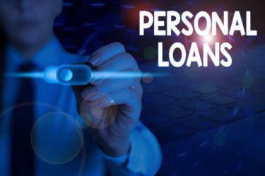 Close-up of a person in a suit pressing a glowing digital button labeled “Personal Loans” on a virtual screen.