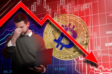 Worried investor holding a laptop in front of a large Bitcoin coin and a red downward market chart, illustrating a crypto crash and broader market decline.
